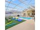 Enclosed pool area with outdoor seating, an artificial turf, and covered dining at 2567 Oneida Loop, Kissimmee, FL 34747