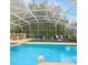 Inviting screened-in pool with lounge chairs and table provides the perfect space for relaxation and entertainment at 2567 Oneida Loop, Kissimmee, FL 34747