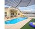 Inviting screened-in pool area with a spa, covered patio, and outdoor dining space at 2567 Oneida Loop, Kissimmee, FL 34747