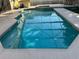 Sparkling pool reflects the screened enclosure above, inviting a refreshing dip in the water at 2567 Oneida Loop, Kissimmee, FL 34747