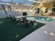 Backyard pool features an artificial lawn and outdoor chairs for a relaxing experience at 2567 Oneida Loop, Kissimmee, FL 34747