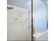 Shower with white tile surround, glass door, and updated shower head at 2567 Oneida Loop, Kissimmee, FL 34747