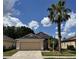Charming single-story home with a well-manicured lawn and mature palm tree at 260 Piccolo Way, Davenport, FL 33896