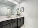 Bathroom with double sinks, dark cabinets, and a glass-enclosed shower at 2970 Protagonist St, Kissimmee, FL 34746