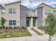 Modern townhome featuring stacked stone accents, lush landscaping, and two vibrant green front doors at 2970 Protagonist St, Kissimmee, FL 34746
