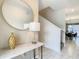 Elegant foyer showcasing a console table with marble top, round mirror, and view into the dining area at 2970 Protagonist St, Kissimmee, FL 34746