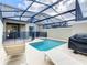 Private screened-in pool and hot tub area with patio chairs and a barbecue, perfect for relaxing outdoors at 2970 Protagonist St, Kissimmee, FL 34746
