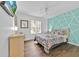 Bright bedroom with a queen bed, geometric accent wall, and wood floors at 303 Plumoso Loop, Davenport, FL 33897