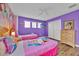 ' bedroom with two twin beds, cartoon wallpaper, wood floors and a ceiling fan at 303 Plumoso Loop, Davenport, FL 33897