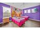 Charming bedroom featuring two twin beds, princess wallpaper, and wood floors at 303 Plumoso Loop, Davenport, FL 33897