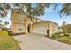 Lovely two-story home boasting an attached two-car garage, arched windows, and manicured landscaping at 303 Plumoso Loop, Davenport, FL 33897