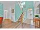 Inviting foyer showcasing wood-look floors, an open staircase, and a decorative arched window above the door at 303 Plumoso Loop, Davenport, FL 33897