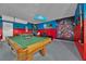 Entertainment room with a pool table, gaming consoles, and vibrant decor perfect for recreation at 303 Plumoso Loop, Davenport, FL 33897