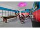Spacious recreational area with a pool table, arcade games, and fun wall decor, ideal for gamers at 303 Plumoso Loop, Davenport, FL 33897