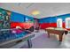 Vibrant game room with gaming setup, a pool table, and themed decor for endless entertainment at 303 Plumoso Loop, Davenport, FL 33897