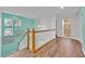 Bright hallway features wood floors and stairs leading to a bathroom with glass shower at 303 Plumoso Loop, Davenport, FL 33897