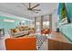 Open-concept living room features a ceiling fan, modern furniture, and glass doors to the outside patio at 303 Plumoso Loop, Davenport, FL 33897