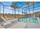 Secluded pool area with comfortable lounge chairs, a volleyball net, and serene views at 303 Plumoso Loop, Davenport, FL 33897