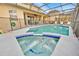 Private pool and spa area with a safety fence, lounge chairs, and beautiful tiling details at 303 Plumoso Loop, Davenport, FL 33897