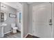 Powder room with white toilet and pedestal sink, with wood-look flooring and gray walls at 320 Southern Winds Blvd, Deland, FL 32720