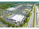 Wide aerial view of a commercial shopping center, with adjacent highway and trees at 3203 Herons Point Cir, Kissimmee, FL 34741