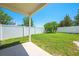 A green fenced backyard featuring grass and a small patio area at 3203 Herons Point Cir, Kissimmee, FL 34741