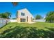 Large, grassy backyard surrounded by a white privacy fence with a small patio at 3203 Herons Point Cir, Kissimmee, FL 34741