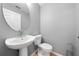 A compact bathroom features a pedestal sink, oval mirror, and toilet in a clean, neutral setting at 3203 Herons Point Cir, Kissimmee, FL 34741