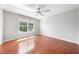 Bright bedroom featuring hardwood floors, neutral walls, large windows, and a ceiling fan at 3203 Herons Point Cir, Kissimmee, FL 34741