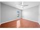 This bedroom features a ceiling fan, neutral walls, hardwood floors, and a window for natural light at 3203 Herons Point Cir, Kissimmee, FL 34741