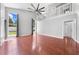 Spacious living room with hardwood floors, large windows with curtains, and a modern ceiling fan at 3203 Herons Point Cir, Kissimmee, FL 34741