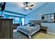 Comfortable bedroom with neutral bedding, tiled floors, and bright blue walls at 330 Chiquita Ct, Kissimmee, FL 34758