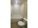 Bright bathroom with a tub-shower combination, tiled walls, and a standard toilet at 4855 Coral Castle Dr, Kissimmee, FL 34746