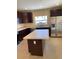 Modern kitchen featuring dark wood cabinets, stainless steel appliances, and a center island at 4855 Coral Castle Dr, Kissimmee, FL 34746