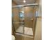 Glass enclosed shower with tile surround, shower head and grab bar at 4855 Coral Castle Dr, Kissimmee, FL 34746