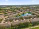 An aerial view displays a townhome community surrounding a serene lake and lush greenery at 4981 Alita Ter, St Cloud, FL 34769