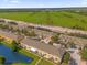 Aerial view showcases a well-maintained townhome community beside a green field and a road at 4981 Alita Ter, St Cloud, FL 34769