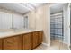 Bathroom with double sink vanity, decorative mirror and a door to a private shower room at 4981 Alita Ter, St Cloud, FL 34769