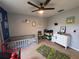 bedroom featuring a patterned rug, blue accent wall, play area, and a white dresser at 4981 Alita Ter, St Cloud, FL 34769