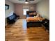 Bedroom featuring hardwood floors, neutral paint, ceiling fan, bed, and black futon at 4981 Alita Ter, St Cloud, FL 34769