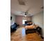Bedroom featuring hardwood floors, neutral paint, ceiling fan, bed, and black futon at 4981 Alita Ter, St Cloud, FL 34769