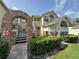Charming condo building featuring brick accents and a welcoming arched entrance under a partially cloudy sky at 5017 Laguna Bay Cir # 96, Kissimmee, FL 34746