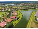 Gorgeous aerial view featuring a villa's tile roof, lush landscaping, canal, and community lake at 517 Milano Rd, Poinciana, FL 34759