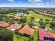 Birds eye view of a villa featuring the tile roof, green lawn, palm trees, and golf course view at 517 Milano Rd, Poinciana, FL 34759