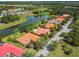 Waterfront homes in a community with mature trees and terracotta roofs from above at 517 Milano Rd, Poinciana, FL 34759