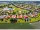 Aerial view of a lakeside home featuring a terracotta roof and mature landscaping at 517 Milano Rd, Poinciana, FL 34759