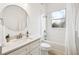 Well-lit bathroom features a shower, bathtub, round mirror, and single sink vanity at 517 Milano Rd, Poinciana, FL 34759