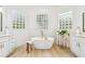 Bright bathroom features a soaking tub, double vanities, and light wood-look tile floors at 517 Milano Rd, Poinciana, FL 34759