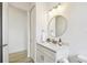 Bright bathroom with wood floors, sink vanity, round mirror, and modern light fixtures at 517 Milano Rd, Poinciana, FL 34759