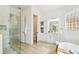 Bathroom with a glass shower, soaking tub, white cabinets and plenty of storage at 517 Milano Rd, Poinciana, FL 34759